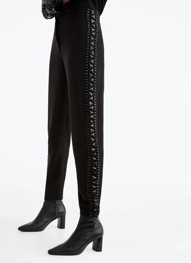 Pantalón negro en color negro y con detalle de pedrería en los laterales, 99 euros (Uterqüe). 