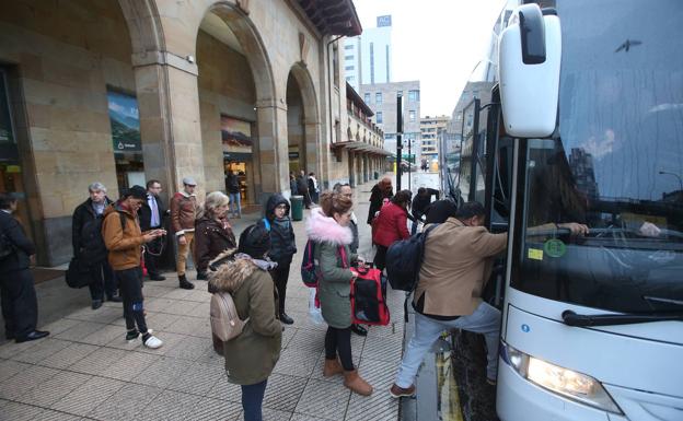 Pasajeros se suben al autobús habilitado por Renfe en la estación de Oviedo.