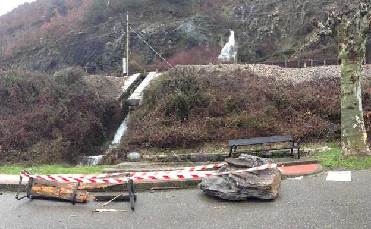 Las rocas que han dañado la vía que comunica Asturias y León han llegado a una zona peatonal, donde han destrozado un banco.