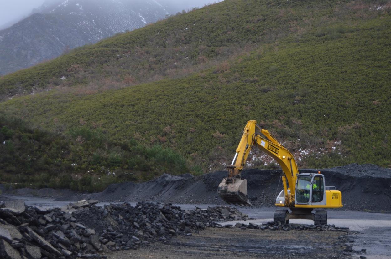 La excavadora trabaja en la retirada de la plataforma de hormigón en la Campa de Tormaleo. 