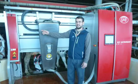Pedro Suárez muestra el funcionamiento de uno de sus robots de ordeño. :: o. villa