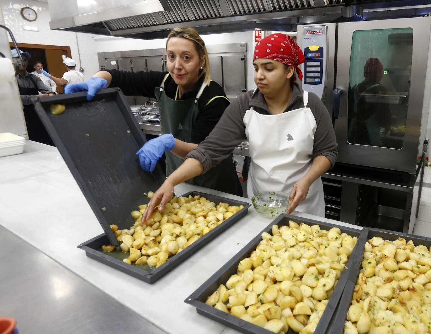 El arzobispo, Jesús Sanz Montes, junto a voluntarios de la Cocina Ecómica, ha servido los menús de Nochebuena.