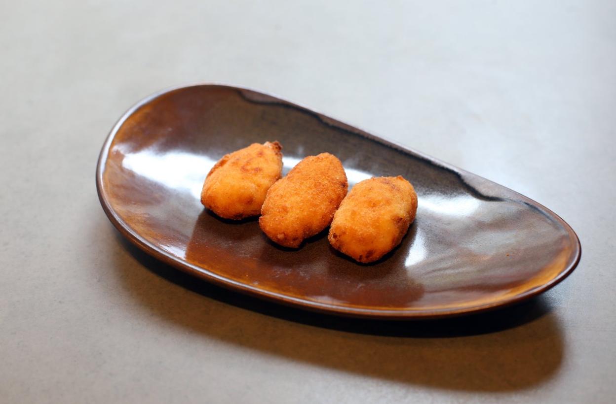 El Foralín. El cocinero Félix Martínez, al frente del restaurante ovetense, sostiene una croqueta de jamón. 