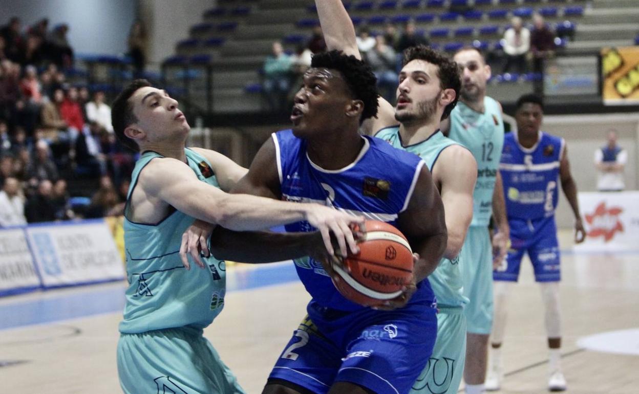 Dos jugadores del Liberbank tratan de frenar un avance del conjunto gallego. 