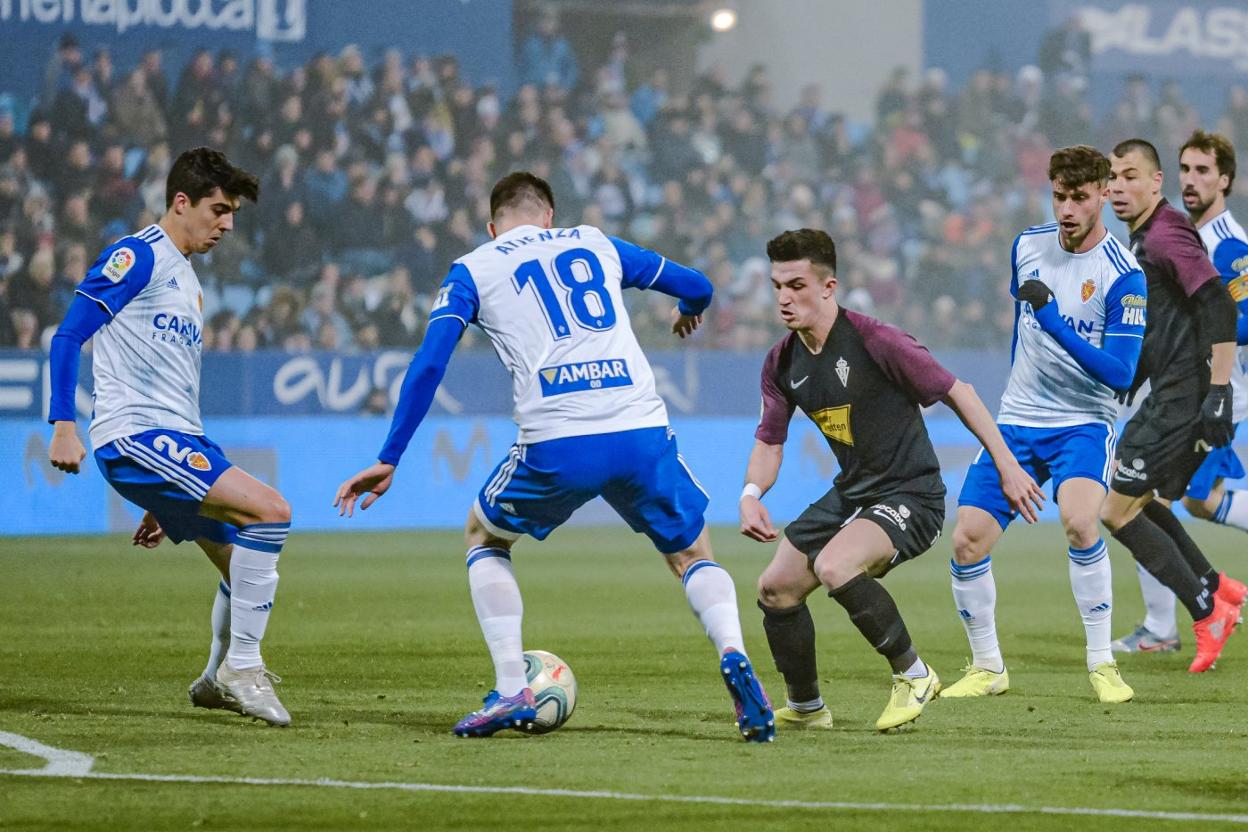 Manu García disputa un balón con dos jugadores del Zaragoza, durante el encuentro disputado en La Romareda. 