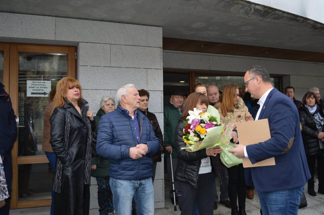 El alcalde, Óscar Ancares, entrega a la madre de Sheila, Julia Fernández, un ramo de flores. 