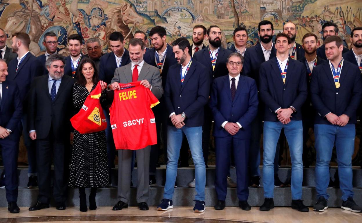 El capitán Raúl Entrerríos, a la derecha, observa cómo doña Letizia y don Felipe despliegan las camisetas con sus nombres. 