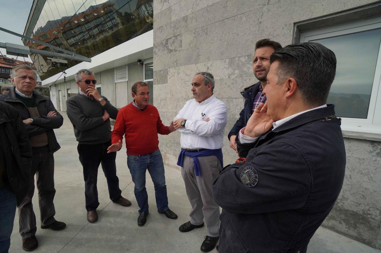 Ángel Batalla se dirige a Javier Brea, Álvaro Queipo y el concejal llanisco Juan Carlos Armas, ayer en el puerto pesquero. 
