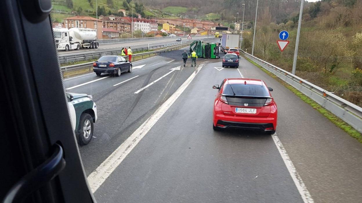 El camión volcado en la vía . 