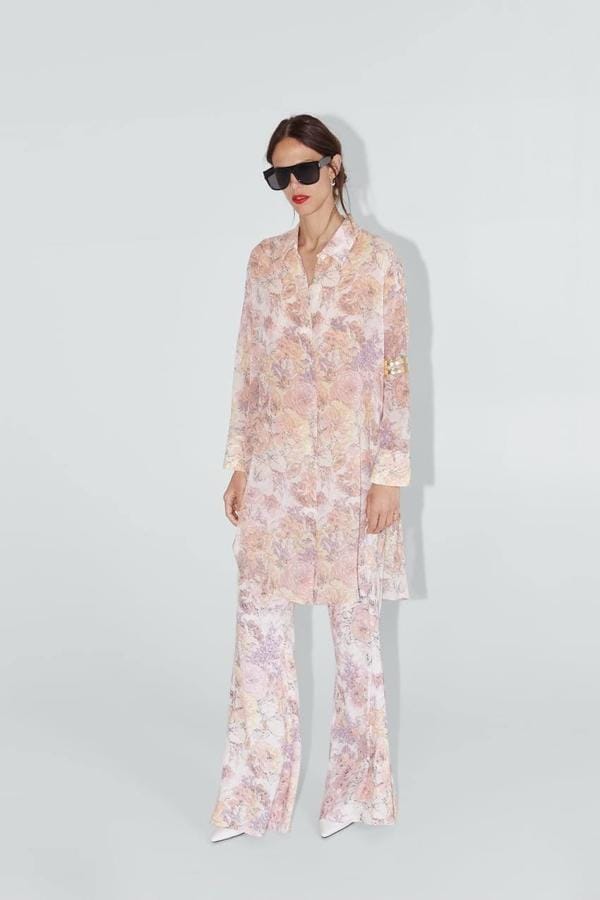 Pantalón flare con estampado floral sobre fondo beige, con diseño fluido y cintura elástica de Zara, 7,99 euros.