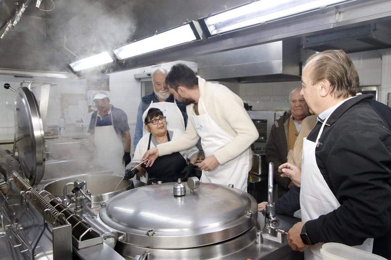 El concejal Alberto Ferrao habla con la cocinera entre, Ricardo Álvarez, de Otea (izquierda, y Luis Torres (derecha). 