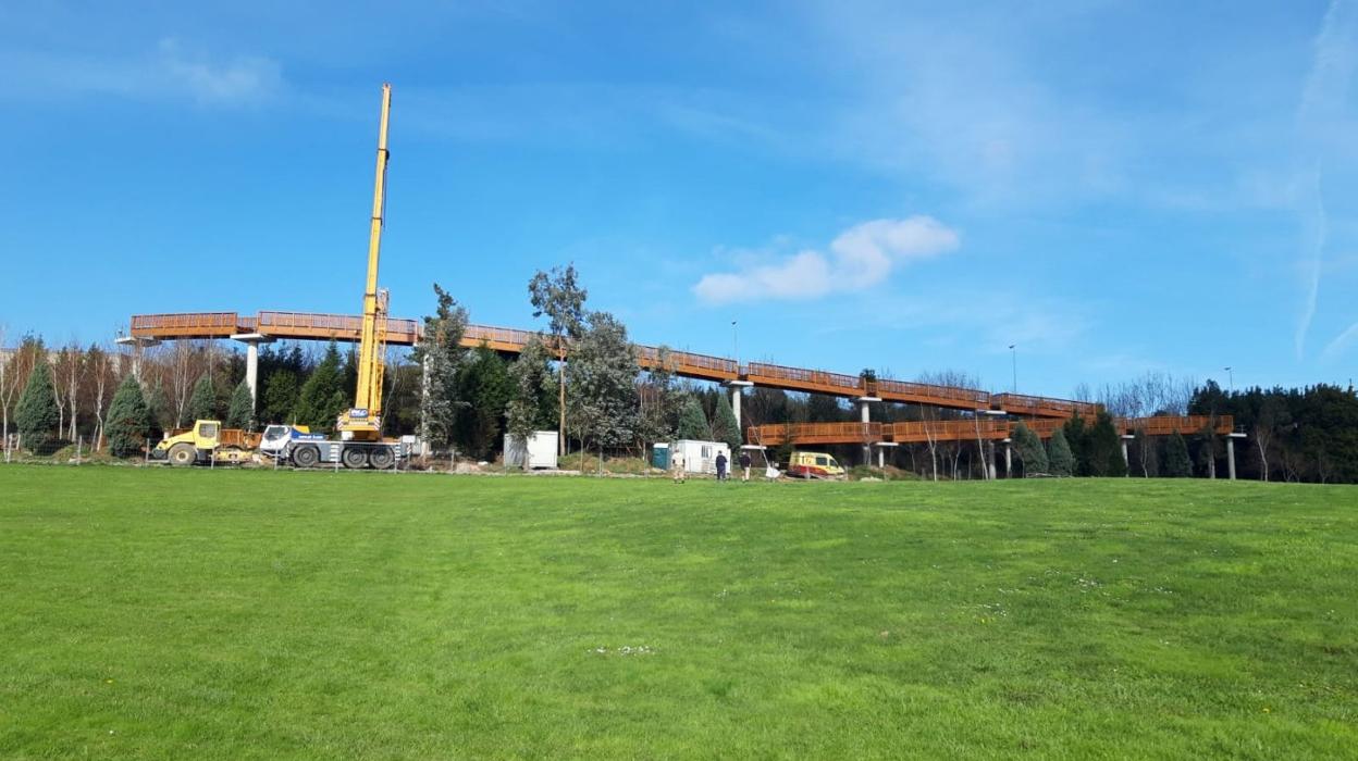 Aspecto de la estructura de madera vista desde las inmediaciones de la escuela infantil de Nuevo Roces y un detalle constructivo en altura. 