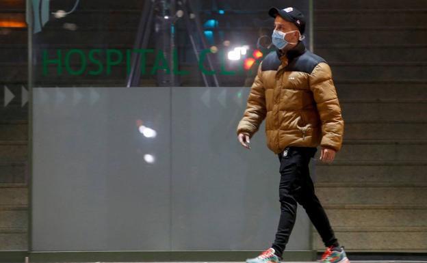 Un hombre pasea con una mascarrilla a la puerta del hospital Clinic de Barcelona.