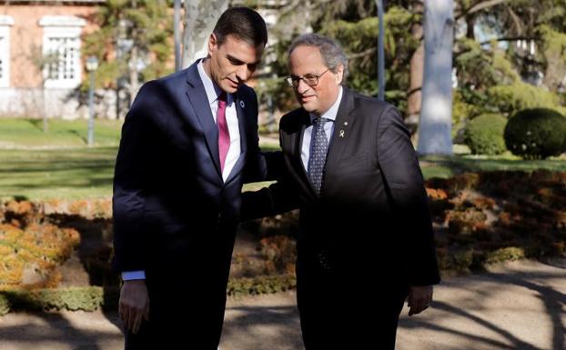 Torra conversa con Sánchez momentos antes de dar inicio a la mesa de diálogo.