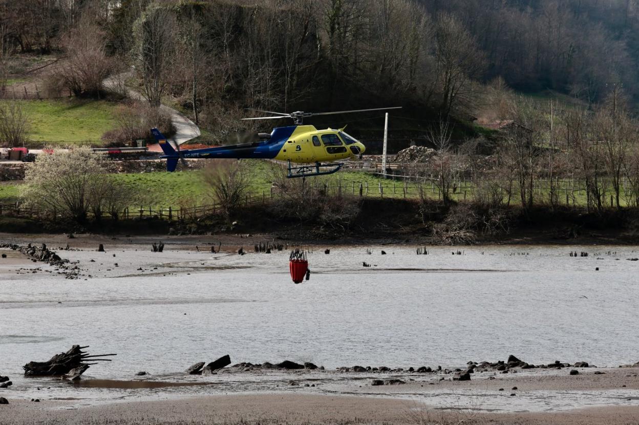 El helicóptero de Bomberos de Asturias se abasteció de agua en el embalse de Rioseco (Sobrescobio). 