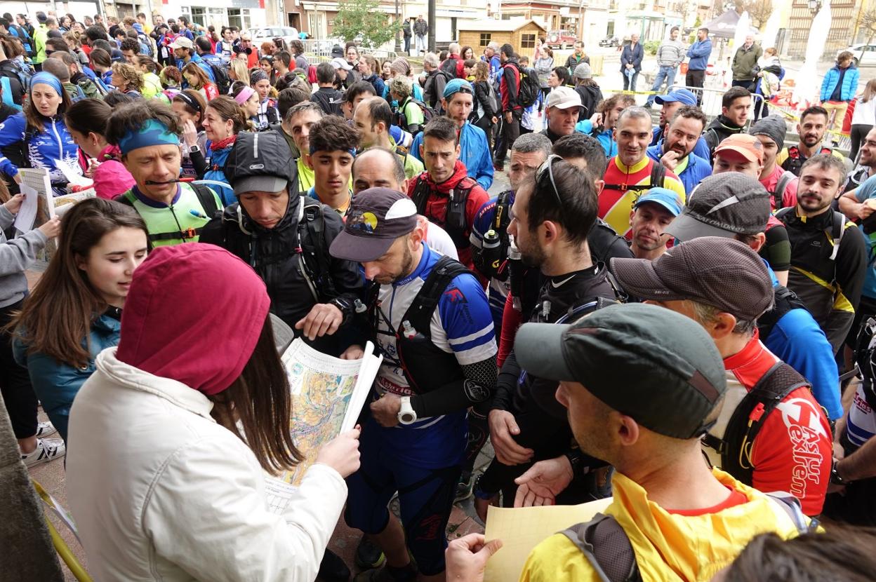 Los deportistas de la Piloña Orienta recogen los mapas necesarios para la prueba en Infiesto. 