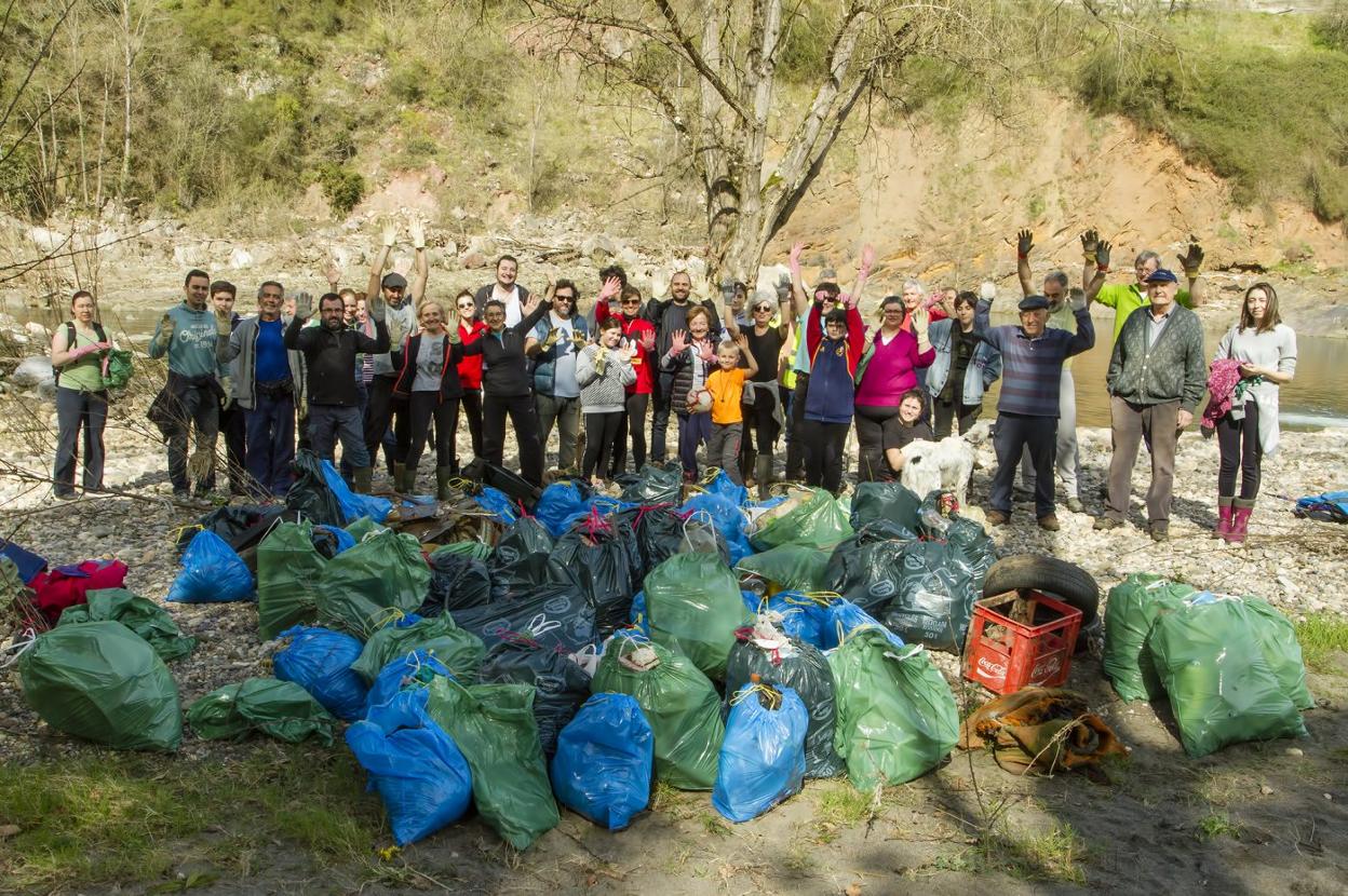 Los vecinos de Udrión con la basura que recogieron ayer de las orillas del Nalón. 