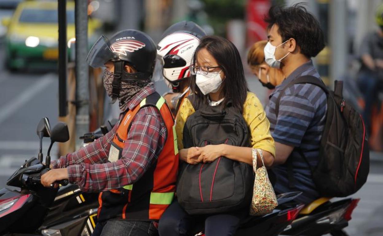 Imagen de ciudadanos tailandeses con mascarillas en Bangkok. 