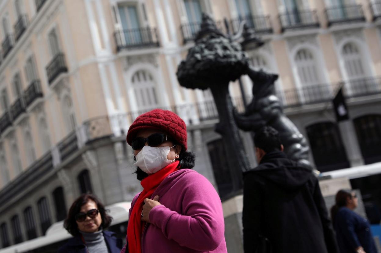 Una turista con mascarilla visita la Puerta del Sol de Madrid. 