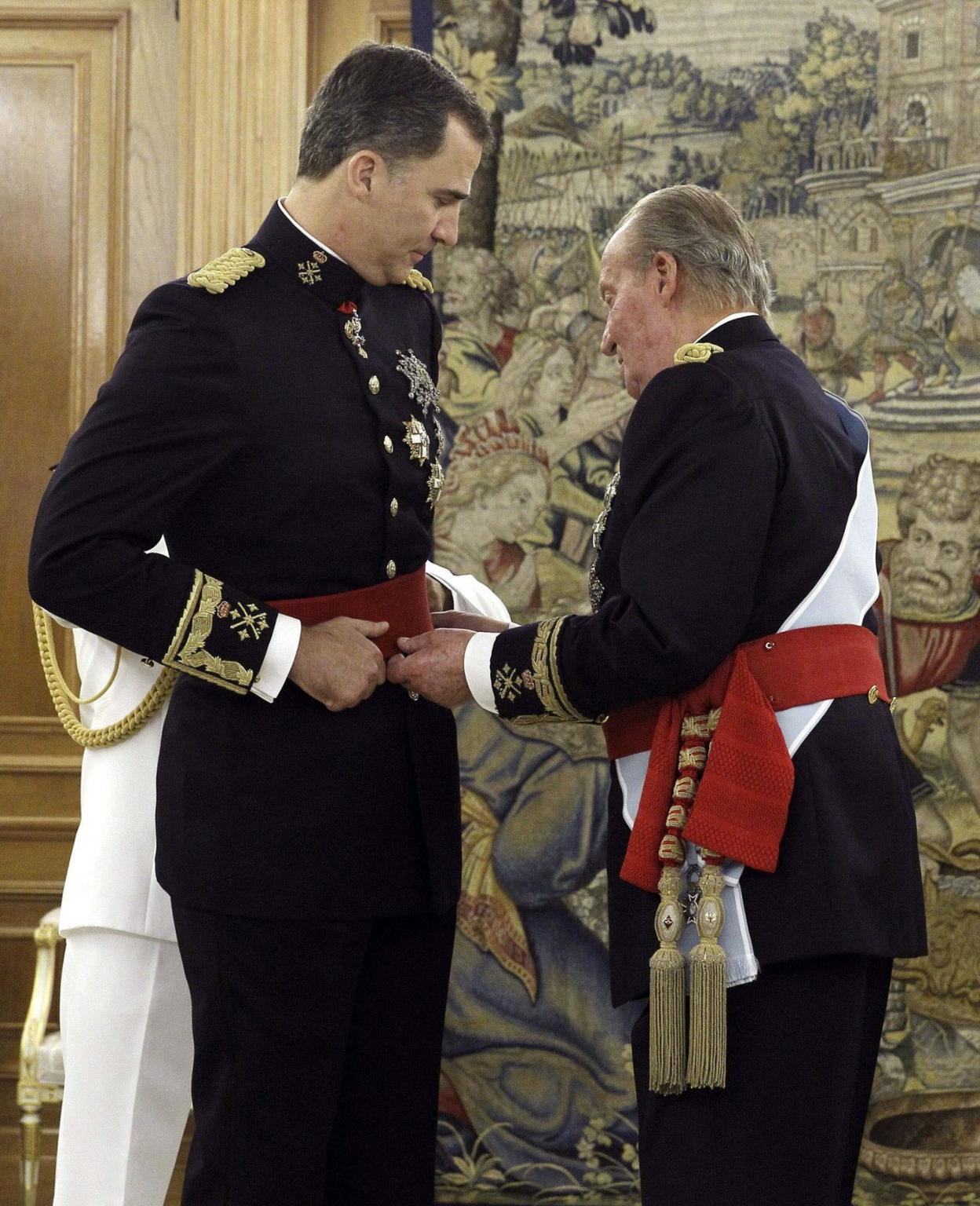 Don Juan Carlos coloca el fajín de Rey a don Felipe, el día de su proclamación en junio de 2014. 