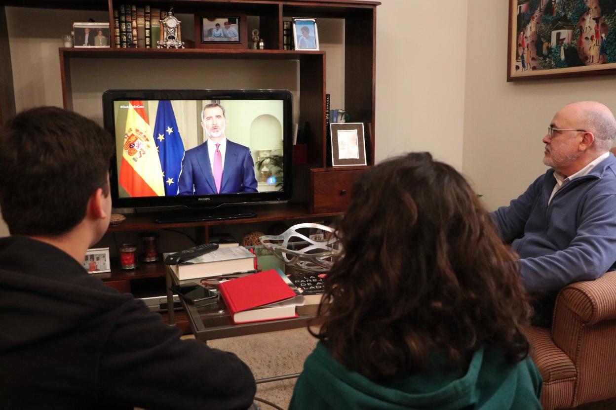 Una familia sigue anoche con atención el discurso televisado del Rey. 