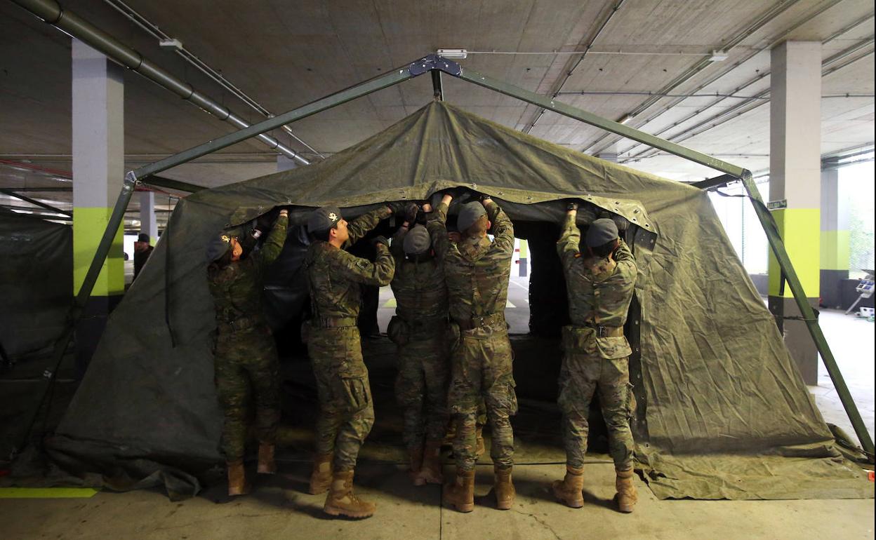 Un grupo de militares preparan el hospital de campaña en el aparcamiento subterráneo del HUCA