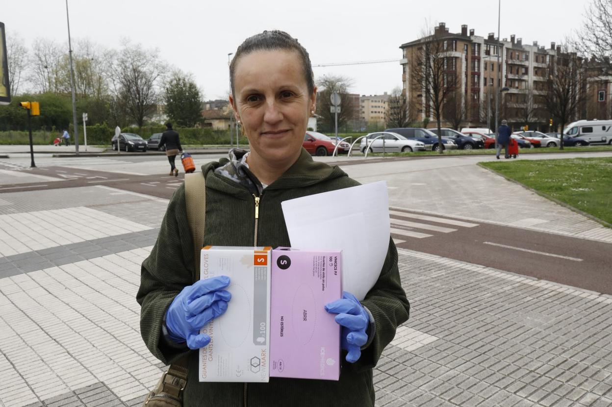 Geli Rodríguez, con dos cajas de guantes, en la avenida de la Constitución, en Gijón. 