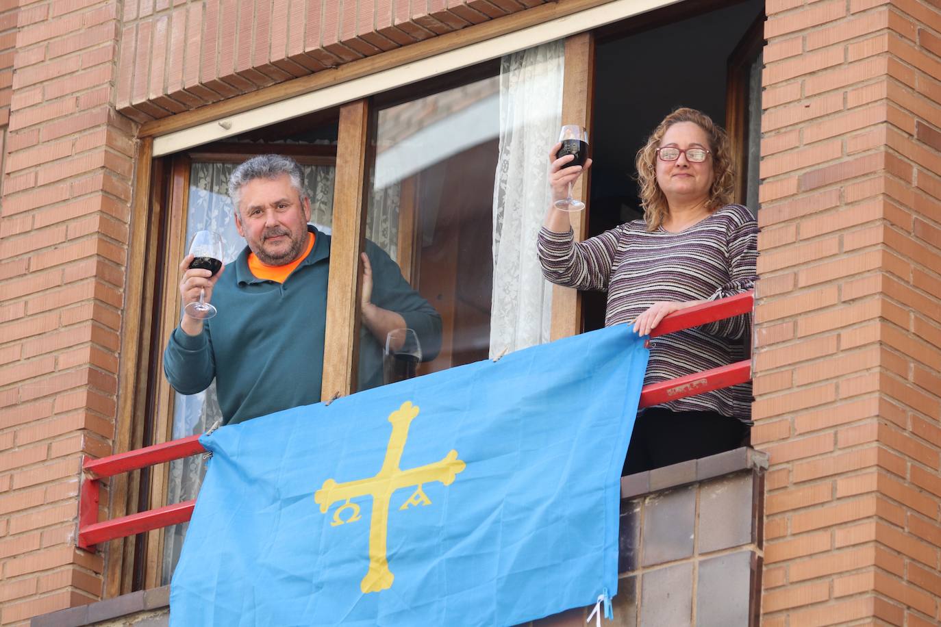 El confinamiento por el coronavirus obliga a reinventar técnicas de socialización. Tanto los asturianos como el resto de españoles no dudan en asomarse al balcón para ver algún rayo de sol, leer o, incluso, tomar el vermú con los vecinos. 