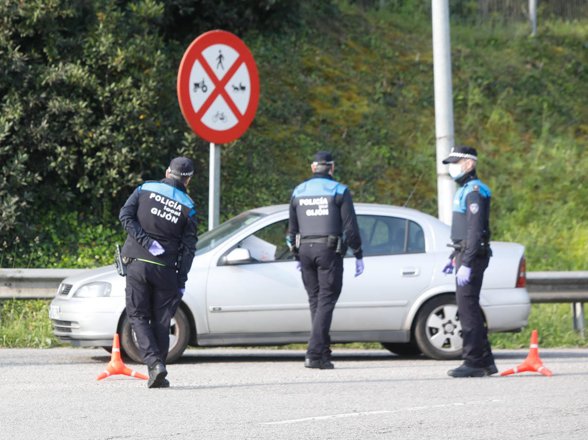 Agentes de la Policía Nacional y Local de Gijón han realizado controles de tráfico este domingo a la entrada y salida de la ciudad para garantizar las medidas de confinamiento decretadas por el Estado de Alarma para contener la pandemia de coronavirus. 