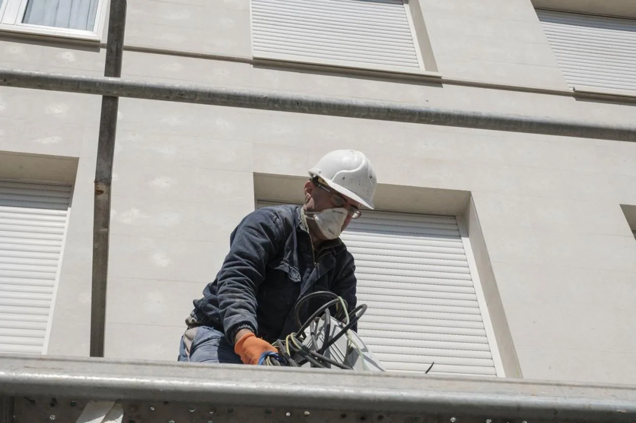 Un trabajador protegido con una mascarilla, en plena faena, en Gijón. 