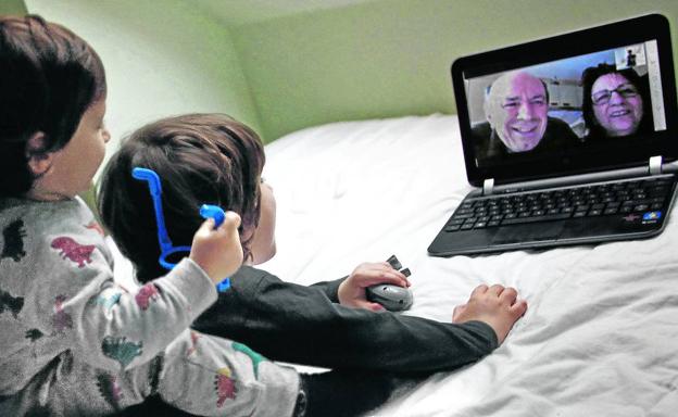 Dos niños gallegos se comunican con sus abuelos por videoconferencia durante el confinamiento por la pandemia.