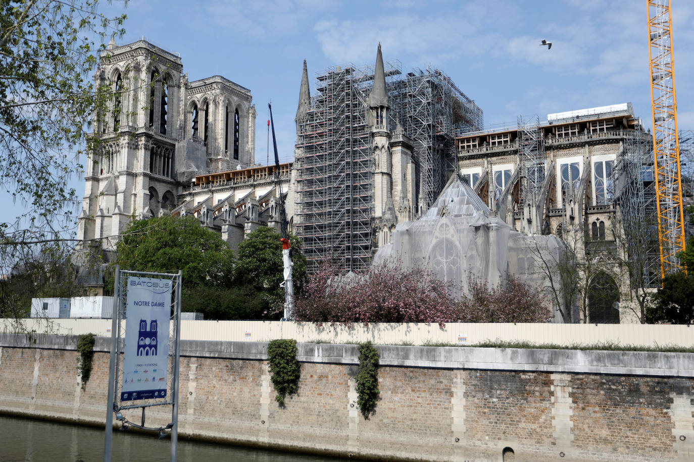 Ocho siglos de historia quedaron en suspenso cuando el 15 de abril de 2019 un incendio derribó la aguja de Notre Dame y su cubierta. Un año después, Francia persiste en su objetivo de reabrir la catedral en 2024, aunque el coronavirus mantenga paralizadas las obras. Las vallas que rodean el templo parisino, la grúa sin movimiento y los andamios que velan por su estructura son reflejo de aquella fatídica tarde, sobre la que la Justicia todavía no ha podido esclarecer el origen de las llamas. El avance de las pesquisas y de la restauración está determinado por la pandemia que ha puesto en hibernación al mundo. Aunque la investigación judicial prosigue en manos de la Brigada Criminal, el análisis técnico se vio frenado cuando este 16 de marzo las obras se suspendieron hasta nueva orden por precaución sanitaria.