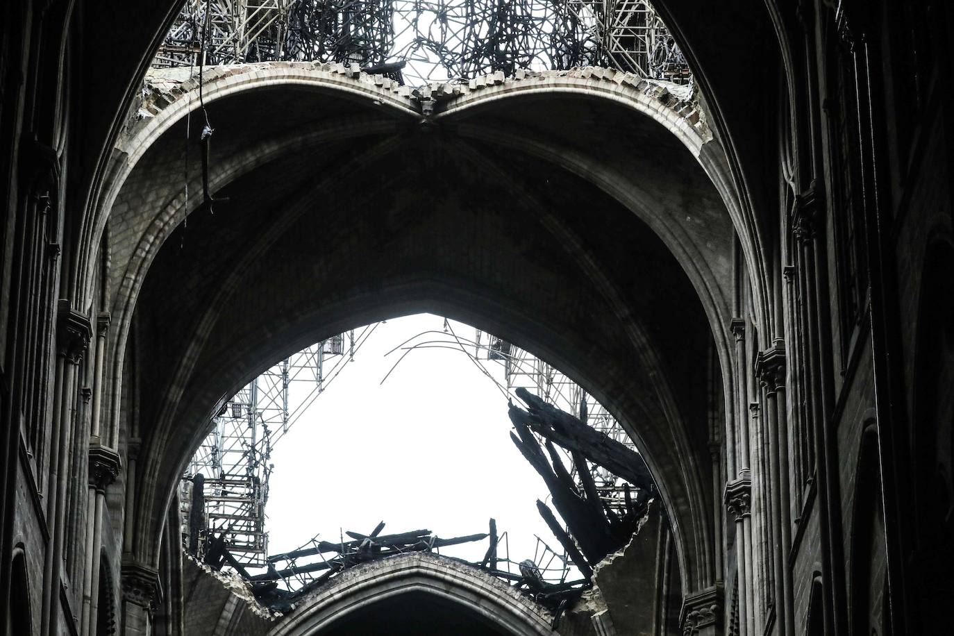 Ocho siglos de historia quedaron en suspenso cuando el 15 de abril de 2019 un incendio derribó la aguja de Notre Dame y su cubierta. Un año después, Francia persiste en su objetivo de reabrir la catedral en 2024, aunque el coronavirus mantenga paralizadas las obras. Las vallas que rodean el templo parisino, la grúa sin movimiento y los andamios que velan por su estructura son reflejo de aquella fatídica tarde, sobre la que la Justicia todavía no ha podido esclarecer el origen de las llamas. El avance de las pesquisas y de la restauración está determinado por la pandemia que ha puesto en hibernación al mundo. Aunque la investigación judicial prosigue en manos de la Brigada Criminal, el análisis técnico se vio frenado cuando este 16 de marzo las obras se suspendieron hasta nueva orden por precaución sanitaria.