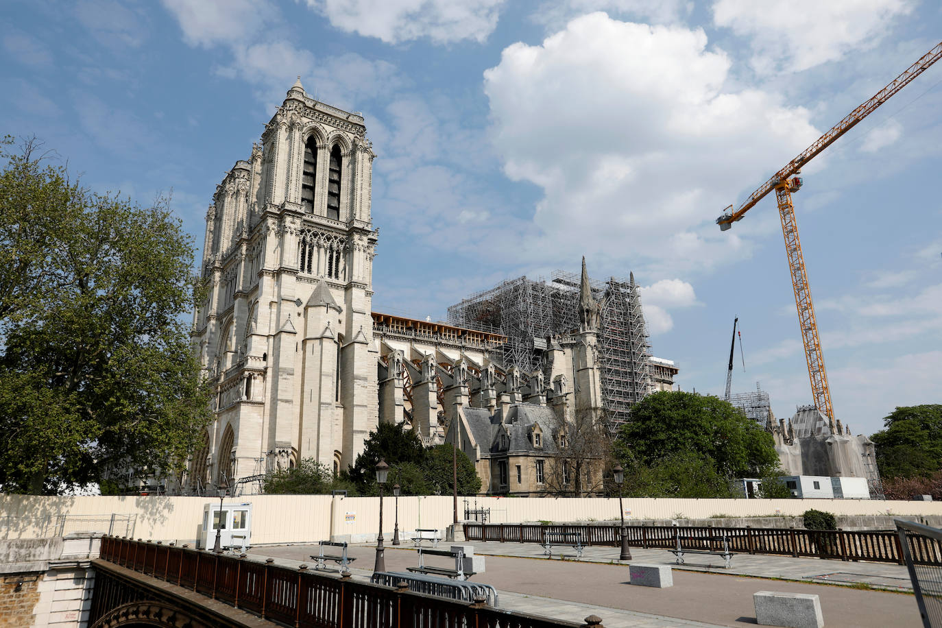 Ocho siglos de historia quedaron en suspenso cuando el 15 de abril de 2019 un incendio derribó la aguja de Notre Dame y su cubierta. Un año después, Francia persiste en su objetivo de reabrir la catedral en 2024, aunque el coronavirus mantenga paralizadas las obras. Las vallas que rodean el templo parisino, la grúa sin movimiento y los andamios que velan por su estructura son reflejo de aquella fatídica tarde, sobre la que la Justicia todavía no ha podido esclarecer el origen de las llamas. El avance de las pesquisas y de la restauración está determinado por la pandemia que ha puesto en hibernación al mundo. Aunque la investigación judicial prosigue en manos de la Brigada Criminal, el análisis técnico se vio frenado cuando este 16 de marzo las obras se suspendieron hasta nueva orden por precaución sanitaria.