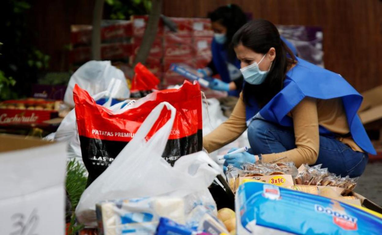 Miembros de la ONG Cesal preparan alimentos y productos básicos de higiene para ser distribuidos a familias vulnerables.