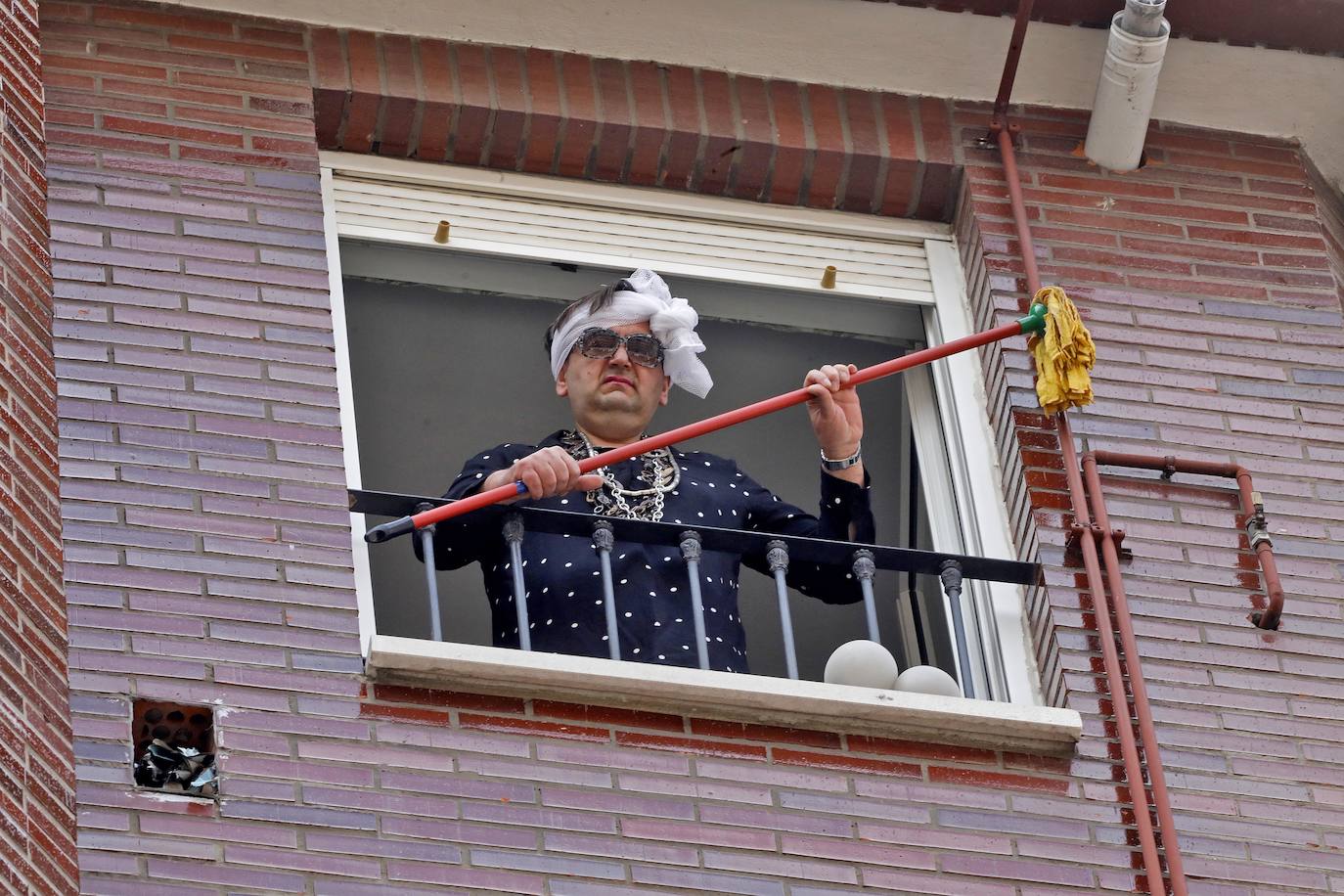 Vecinos del barrio de Contrueces se divierten este domingo desde sus ventanas emulando la estética del videoclip de Queen 'I want to break free'. 