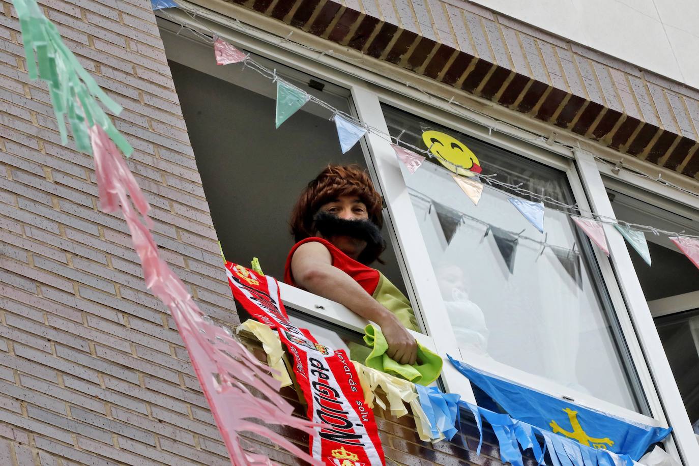 Vecinos del barrio de Contrueces se divierten este domingo desde sus ventanas emulando la estética del videoclip de Queen 'I want to break free'. 