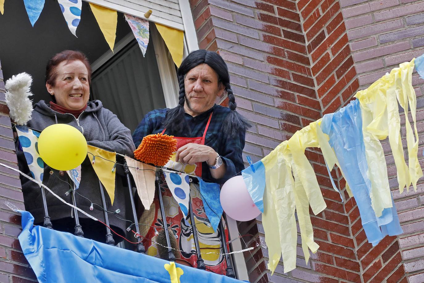 Vecinos del barrio de Contrueces se divierten este domingo desde sus ventanas emulando la estética del videoclip de Queen 'I want to break free'. 