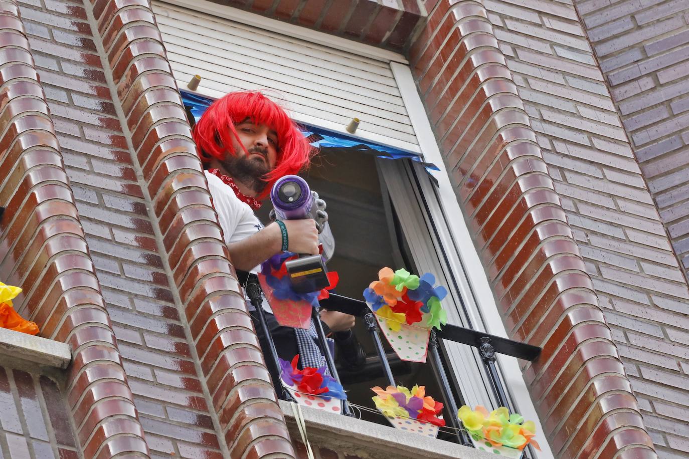 Vecinos del barrio de Contrueces se divierten este domingo desde sus ventanas emulando la estética del videoclip de Queen 'I want to break free'. 