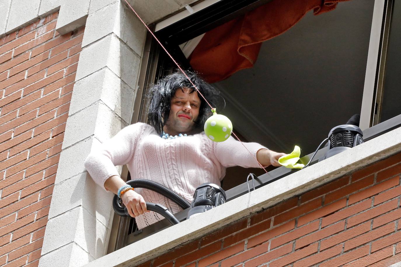 Vecinos del barrio de Contrueces se divierten este domingo desde sus ventanas emulando la estética del videoclip de Queen 'I want to break free'. 