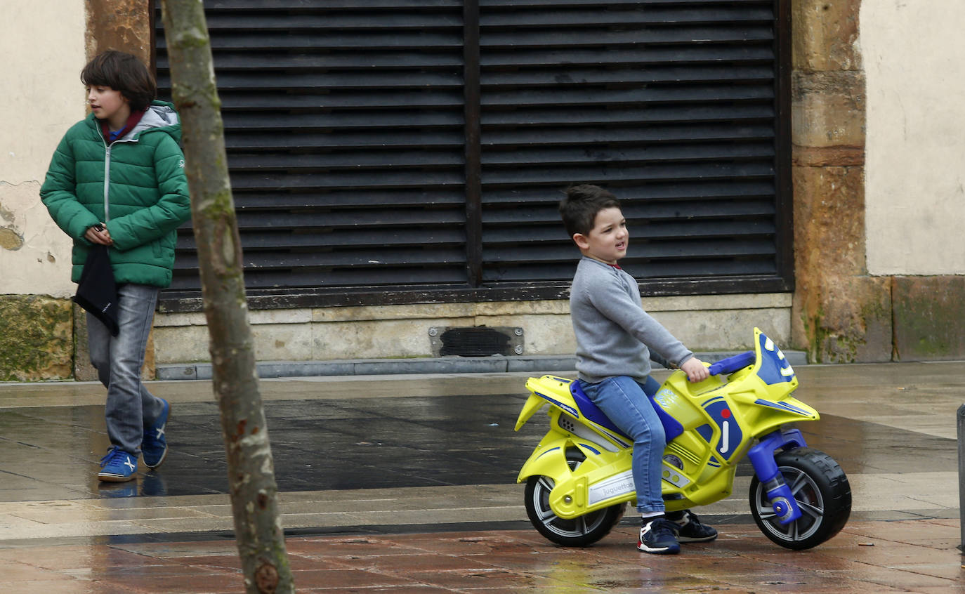 Los niños de Oviedo ponen al mal tiempo buena cara y salen a disfrutar de sus calles