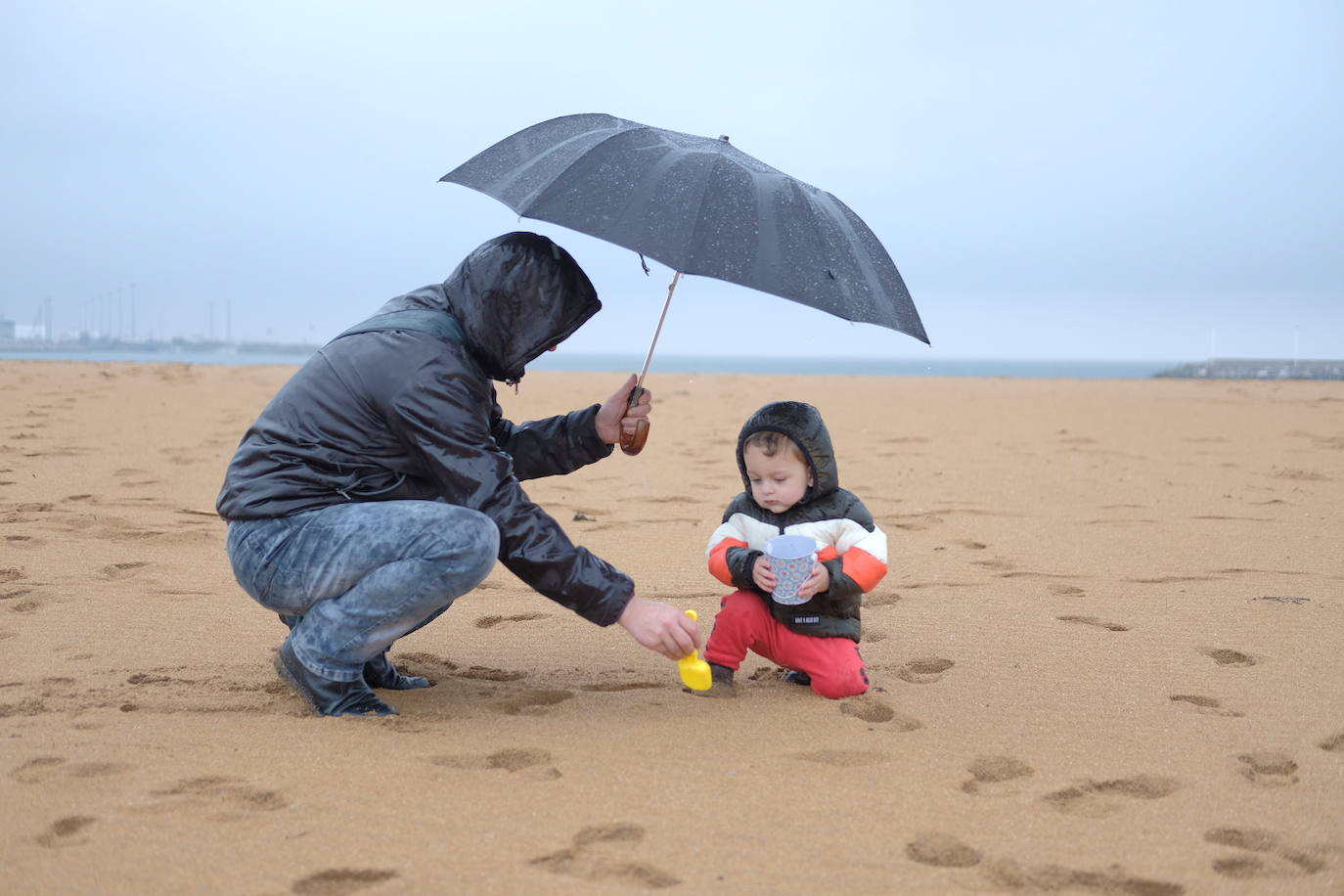 Primeros paseos bajo el orbayu en Gijón de los más pequeños