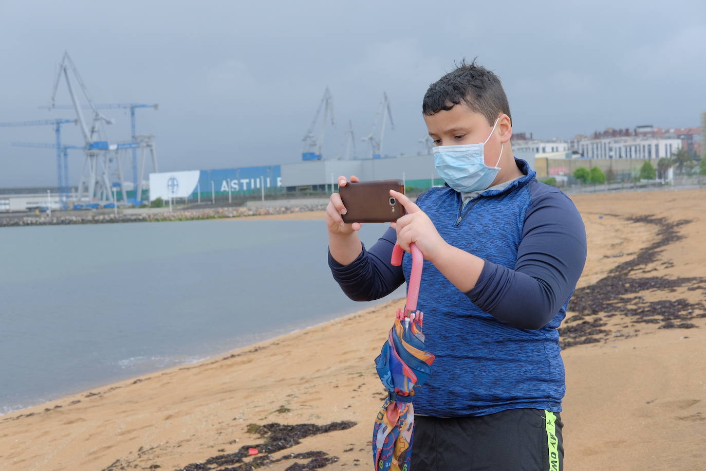 Primeros paseos bajo el orbayu en Gijón de los más pequeños