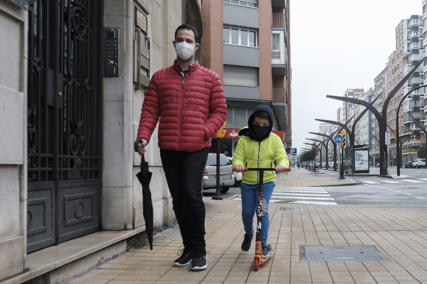 Primeros paseos bajo el orbayu en Gijón de los más pequeños