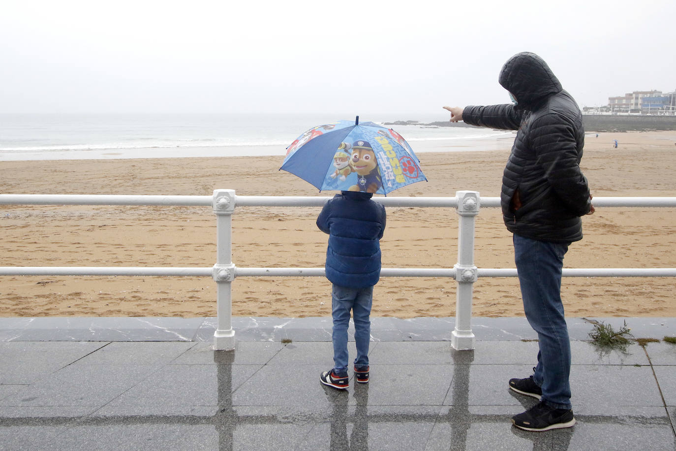 Primeros paseos bajo el orbayu en Gijón de los más pequeños