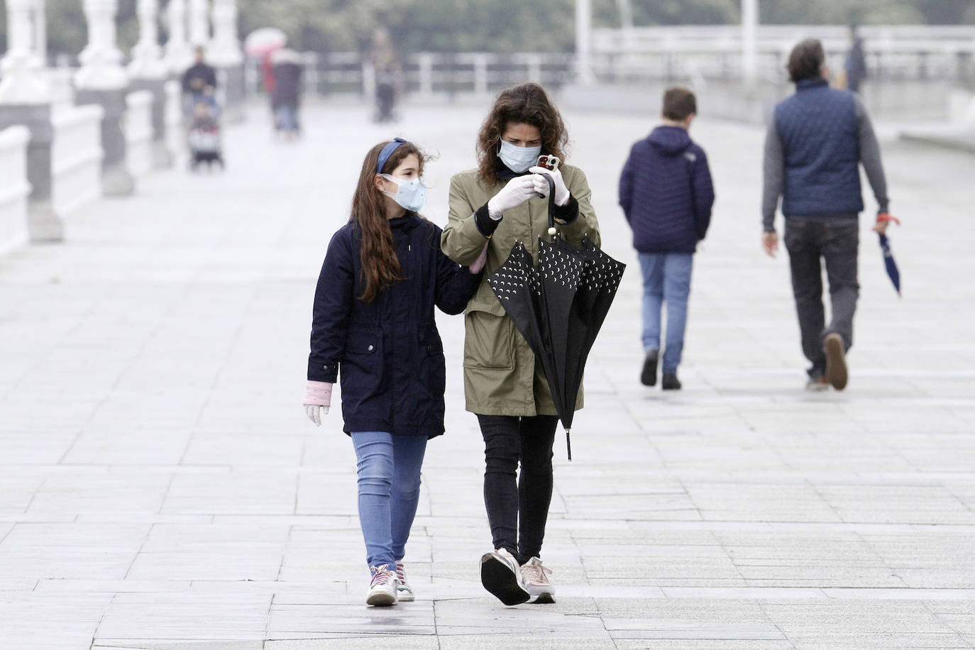 Primeros paseos bajo el orbayu en Gijón de los más pequeños