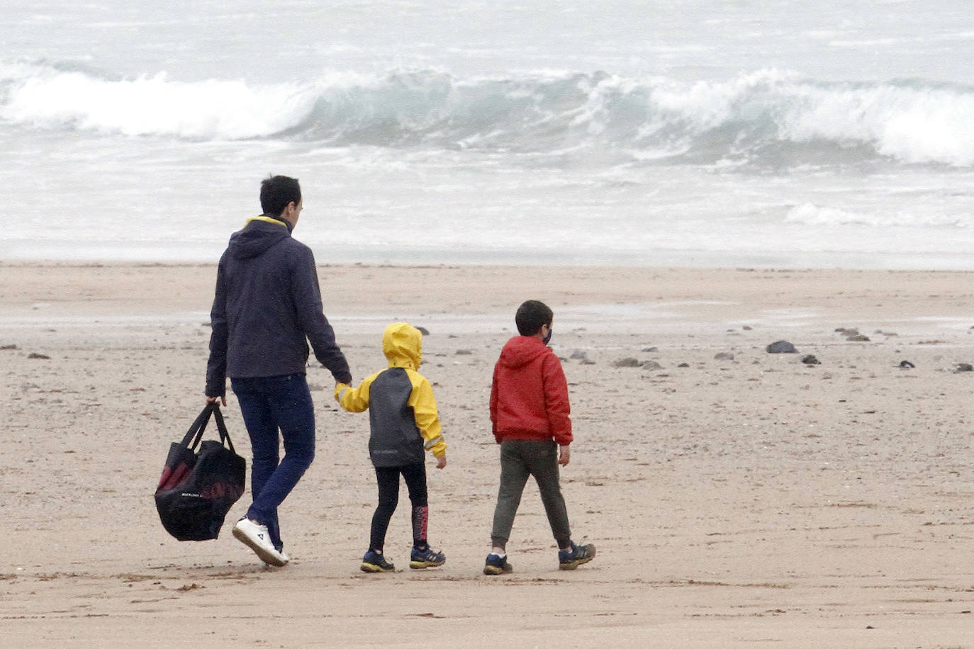 Primeros paseos bajo el orbayu en Gijón de los más pequeños