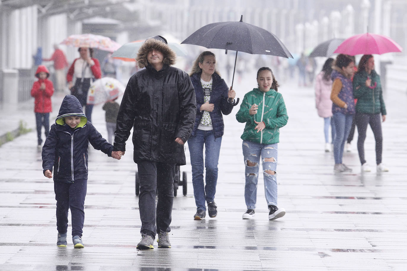 Primeros paseos bajo el orbayu en Gijón de los más pequeños