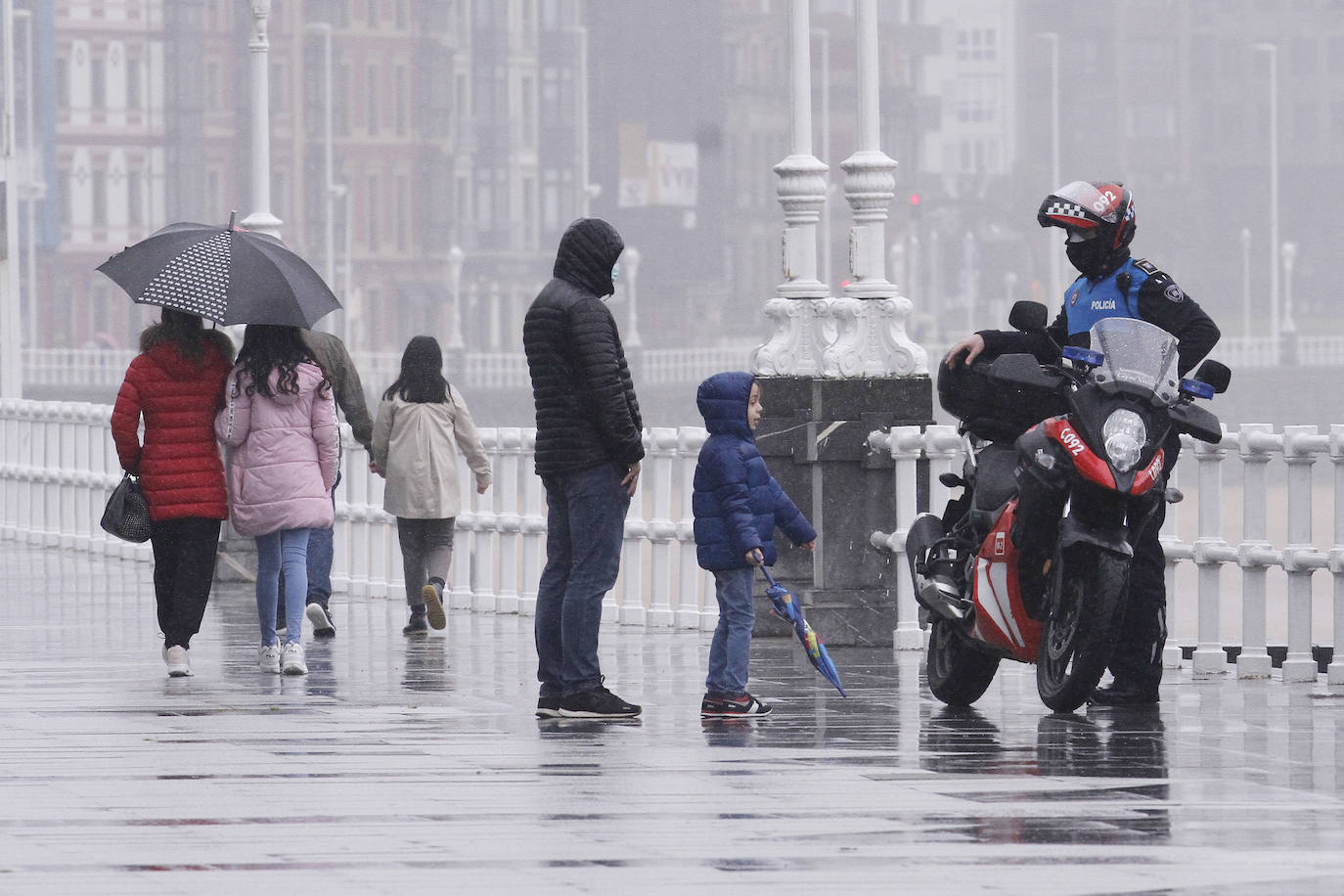 Primeros paseos bajo el orbayu en Gijón de los más pequeños