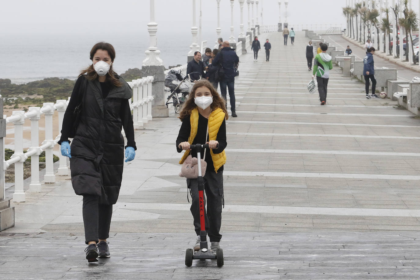 Primeros paseos bajo el orbayu en Gijón de los más pequeños